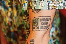  ?? Yalonda M. James/The Chronicle ?? Mychal Threets’ love of libraries extends to his tattoos, including one of a library card. His social media videos have encouraged more people to come to his library.