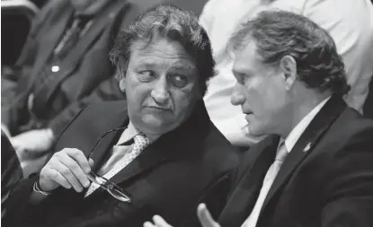  ?? WAYNE CUDDINGTON/OTTAWA CITIZEN ?? Eugene Melnyk, left, and Cyril Leeder confer during a city finance committee meeting on the location of a new casino in June. Melnyk is losing an average of $9 million to $10 million a year on the Senators, which could explain why he wanted a casino at...