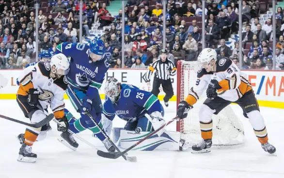  ?? DARRYL DYCK/THE CANADIAN PRESS ?? The Anaheim Ducks’ Andrew Cogliano and Jakob Silfverber­g pressure Canucks goalie Jacob Markstrom as Alex Edler defends at Rogers Arena on Tuesday.