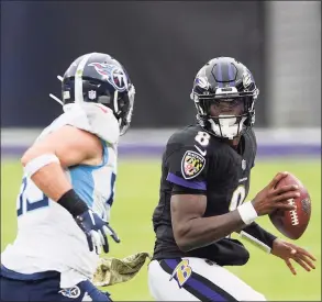  ?? Nick Wass / Associated Press ?? Ravens quarterbac­k Lamar Jackson, right, in action against the Titans during Sunday’s game in Baltimore.