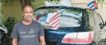  ?? JUAN CARLOS CHAVEZ/TNS ?? Daniel Llorente, 58, decorated the rear window of his old SUV with a photo of him and his son, embracing an American flag.