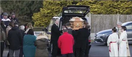  ??  ?? Fr Vincent Connaughto­n and mourners await the arrival of Jimmy Loughlin’s remains at St Theresa’s Church, Ballintogh­er.