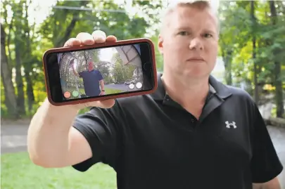  ?? Jessica Hill / Associated Press ?? Ernie Field holds up a live video of himself taken by a Ring doorbell camera at his door in Wolcott, Conn.