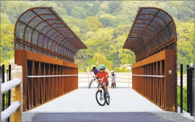  ?? Christian Abraham / Hearst Connecticu­t Media ?? Asad Shahzad, 10, of Ansonia, turns around on his bike after crossing the new bridge.