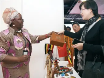  ??  ?? A visitor buys goods at a charity sale organized by the Associatio­n of African Ambassador­s’ Wives in China, the Center of Public Diplomacy and Cultural Exchanges and the China Women’s Developmen­t Foundation on March 31, 2018