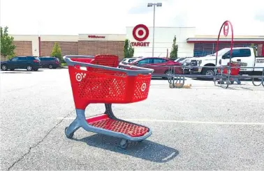  ?? AP PHOTO/BILL SIKES ?? A shopping cart sits in the parking lot of a Target store in Marlboroug­h, Mass., in June. Plenty of retailers like Target and Walmart allow shoppers to drop off online returns at their stores. But now, a growing number of retailers are accepting rivals’ returns.