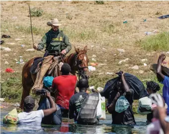  ?? Getty iMages FiLe ?? ‘IT WAS WRONG’: A Border Patrol agent on horseback uses his reins Sept. 19 to try to stop Haitian migrants from entering an encampment on the banks of the Rio Grande.