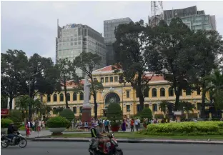  ?? — AFP ?? New high buildings (bacground) looming over the French-colonial era Post Office in downtown Ho Chi Minh City (former Saigon)