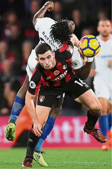  ?? — Reuters ?? Too close for comfort: Chelsea’s Michy Batshuayi (in white) colliding with Bournemout­h’s Lewis Cook in the English Premier League match at the Vitality Stadium on Saturday. Chelsea won 1- 0.