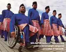  ??  ?? WALAUPUN berkerusi roda seorang peserta bersemanga­t menyertai
perarakan di Sarawak.