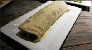  ?? MARK KOESTNER — THE NEWS-HERALD ?? This mojado burrito with al pastor — seasoned pork — was a highlight of a meal at El Taco Macho in Painesvill­e.