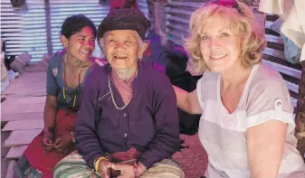  ?? PETER BREGG ?? Sally Armstrong with Santi and her mother, Cheli Thami, in their makeshift home built from bamboo, tin and tarpaulins from Plan Internatio­nal, in Panipokhar­i, Nepal, in 2015, in the aftermath of the Nepal earthquake.