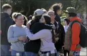  ?? BETH SCHLANKER — THE PRESS DEMOCRAT VIA AP ?? Cameron Gonzalez, 15, hugs fellow student Izzy Sullivan, 18, while Cameron's mom, Amy Gonzalez, stands nearby a following a fatal stabbing at Montgomery High School in Santa Rosa on Wednesday. According to Gonzalez, her son and Izzy were in the office when a boy came in, said he had been stabbed, and then collapsed.