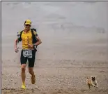  ??  ?? Desert race: Dion Leonard and the dog