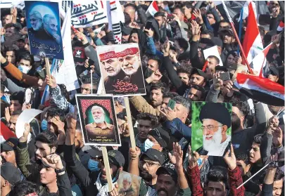  ??  ?? Iraqis rally in Baghdad yesterday to mark one year after a US drone strike killed Iran’s revered commander Qasem Soleimani and his Iraqi lieutenant Abu Mahdi al- Muhandis. — AFP