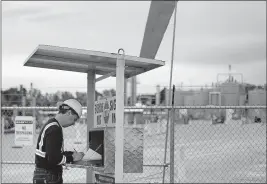  ??  ?? Robert Mchale, of Markwest Energy Partners, signs in to the Humphreys compressor station in Barnesvill­e. The station pressurize­s natural gas after it has been extracted from the ground.