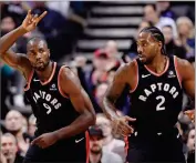  ?? NATHAN DENETTE ?? Toronto Raptors forward Serge Ibaka (9) celebrates a basket against the Charlotte Hornets with teammate Kawhi Leonard (2) during firsthalf NBA basketball game action in Toronto, Monday, Oct. 22.