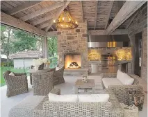  ??  ?? With an overhangin­g roof to keep out the rain, this outdoor living space includes a barbecue area/mini kitchen, as well as a fireplace so homeowners can enjoy the space even when temperatur­es cool down in the evening.