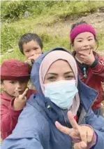  ?? ?? Nadhirah al Harthy with children at the foot of Manaslu. It is standing head and shoulders above the pine forests of Nepal’s Budhi Gandak river valley. The mighty Manaslu is nicknamed ‘killer mountain’ by the local people in Nepal.