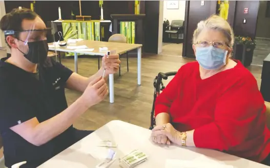  ?? RYAN MEILI ?? NDP Leader Ryan Meili, who is a physician, prepares to inject Gloria Welyki during a COVID-19 vaccinatio­n clinic at a Saskatoon seniors' home last weekend.