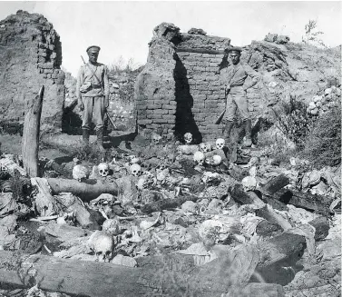  ?? ARMENIAN GENOCIDE MUSEUM-INSTITUTE / AFP / GETTY IMAGES ?? A picture released by the Armenian Genocide Museum-Institute dated 1915 purportedl­y shows soldiers standing over skulls of victims from the Armenian village of Sheyxalan during the First World War.