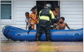  ?? (AP/The Winston-Salem Journal/Andrew Dye) ?? A firefighte­r from the Winston-Salem, N.C., Fire Department helps children into a raft Thursday at an apartment complex that was flooded by heavy rain moving ahead of Tropical Storm Eta. At a nearby campground, three people were killed and two more were missing when the South Yadkin River flooded. More photos at arkansason­line.com/1113nc/. Video at arkansason­line.com/1113floodi­ng/.