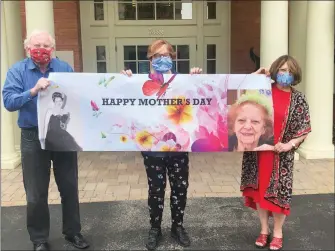  ?? SHELLY SOLOMON VIA AP ?? THIS MAY 3 PHOTO RELEASED BY SHELLY SOLOMON SHOWS ( from left) Steve Turner and his sisters, Carla Paull and Lisa Fishman, holding up a Mother’s Day banner emblazoned with images of their mom, Beverly Turner, in front of her assisted living facility in Ladue, Missouri. They were “practicing” how their Mother’s Day surprise will look on the holiday as their mother peers down from a window. Isolation due to the coronaviru­s outbreak has led mothers and offspring to find creative ways to celebrate.