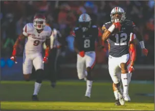  ?? The Associated Press ?? GOING, GONE: Eli Stove’s 70-yard touchdown run on the first play of the game sets the tone for Auburn’s 56-3 rout of Arkansas Saturday night. The Tigers play at Ole Miss this week while Arkansas is off until a Nov. 5 home game against Florida.