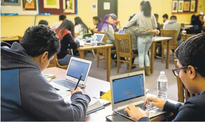  ?? LIPO CHING/STAFF ?? Overfelt High School students Bryan Pineda, 15, left, and Ricardo Carrasco, 15, work using Chromebook­s and the internet at the school library. The East Side school district is partnering with the city of San Jose to bring free internet access to some...