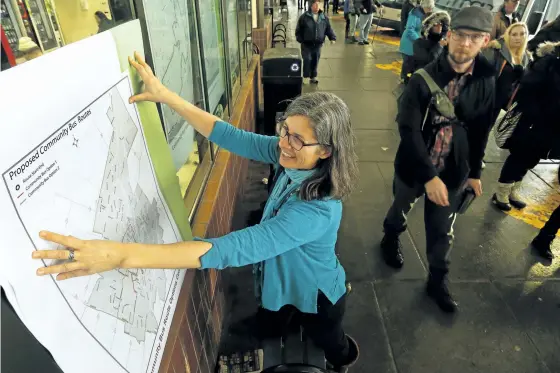  ?? CLIFFORD SKARSTEDT/EXAMINER ?? Transporta­tion demand management planner Susan Sauve of city’s utility services department with proposed community bus routes on Wednesday at the Peterborou­gh Transit Terminal on Simcoe St.