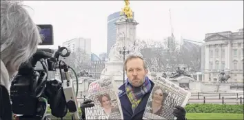  ?? Kirsty Wiggleswor­th / AP ?? A television journalist holds up two British newspapers as he speaks outside Buckingham Palace in London on Monday following a television interview by Prince Harry and Meghan.