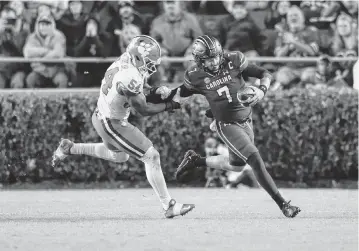  ?? SAM WOLFE Special To The State ?? South Carolina quarterbac­k Spencer Rattler (7) is chased down by Clemson linebacker Jeremiah Trotter Jr. (54) during the second half of South Carolina’s game against Clemson at Williams-brice Stadium in Columbia on Nov. 25, 2023.