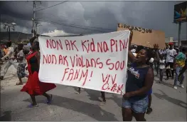  ?? JOSEPH ODELYN — THE ASSOCIATED PRESS ?? People protest carrying a banner with a message that reads in Creole: “No to kidnapping­s, no to violence against women ! Long live Christian Aid Ministries,” demanding the release of kidnapped missionari­es, in Titanyen, north of Port-au-Prince, Haiti, on Tuesday,