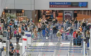  ?? (AFP) ?? Travellers queue up at check-in counters in Dusseldorf airport on Friday as summer holidays begin in this western German area