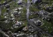  ?? GERALD HERBERT — THE ASSOCIATED PRESS FILE ?? Debris scatters a destroyed community in the aftermath of Hurricane Maria in Toa Alta, Puerto Rico.