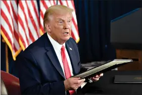  ?? (AP Photo/Susan Walsh) ?? President Donald Trump prepares to sign four executive orders during a news conference Saturday at the Trump National Golf Club in Bedminster, N.J. Seizing the power of his podium and his pen, Trump on Saturday moved to bypass the nation’s elected lawmakers as he claimed the authority to defer payroll taxes and extend an expired unemployme­nt benefit after negotiatio­ns with Congress on a new coronaviru­s rescue package collapsed.