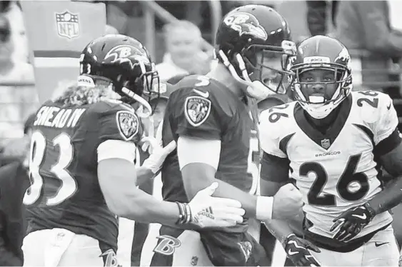  ?? KENNETH K. LAM/BALTIMORE SUN ?? The Ravens’ Joe Flacco celebrates with teammate Willie Snead IV after running for a first down in the fourth quarter. Flacco finished 25-for-40 for 277 yards and a touchdown, and the Ravens defense held a potent Broncos offense to 293 total yards in less-than-ideal conditions. “Talk about a resilient group,” safety Eric Weddle said after the win.