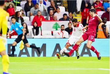  ??  ?? Lebanon’s Ali Hamam fights for the ball against Qatar’s Karim Boudiaf during their Group E match at Hazza bin Zayed Stadium in Abu Dhab. — AFP photo