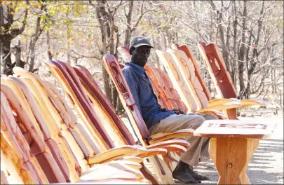  ?? — Picture by Kudakwashe Hunda ?? Enterprisi­ng and gifted Mr Tim Dhimba sells wood-crafted chairs at Tinde turn-off along Binga-Bulawayo Highway last week. Craftsmen take advantage of abundant indigenous trees in the area to produce furniture for sale.