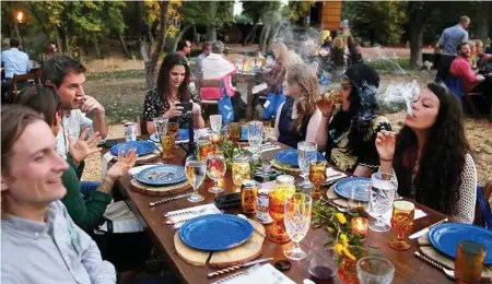  ?? Brennan Linsley / Associated Press ?? Diners smoke marijuana as they eat dishes prepared by chefs during an evening of pairings of fine food and craft marijuana strains served to invited guests dining at Planet Bluegrass, an outdoor venue in Lyons, Colo.