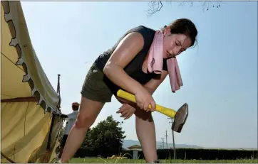  ?? DOUG DURAN — STAFF PHOTOGRAPH­ER ?? Chelsea Elledge, of Sacramento, hammers a tent stake into the ground ahead of this weekend’s 152nd Scottish Highland Gathering &amp; Games in Pleasanton, where Saturday temperatur­es should top triple digits.