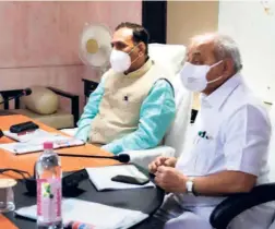  ??  ?? GUJARAT CHIEF MINISTER Vijay Rupani and Deputy Chief Minister Nitin Patel at a meeting to take stock of the COVID-19 situation, in Surat on July 4.