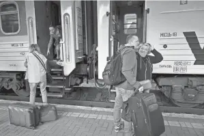  ?? SERGEI SUPINSKY/AFP VIA GETTY IMAGES ?? A woman is greeted by her husband Thursday at Kyiv’s railway station upon her arrival from Poland. For the first time since the start of the war, the flow was reversed Tuesday, with 29,000 departures for 34,000 returns according to official figures from border guards.