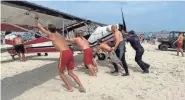  ?? FIRE DEPARTMENT ?? First responders, including Hampton Beach lifeguards, push a small plane that crashed in the water about 30 yards off shore around noon Saturday, July 29.PROVIDED/HAMPTON