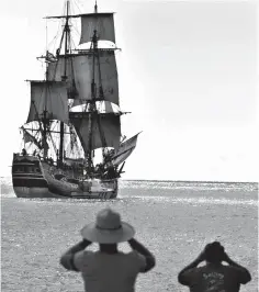  ?? Associated Press ?? ■ In this Nov. 15, 1999, file photo, people watch as a replica of the HMB Endeavour leaves Honolulu as it embarked on a four-year, around-the-world cruise. The original vessel was commanded by Capt. James Cook in the 1700s when he became the first European to chart Australia's East Coast. Researcher­s said this month they've found a site where they think the ship that Cook used sank and may be located and are planning an excavation off the coast of Rhode Island.