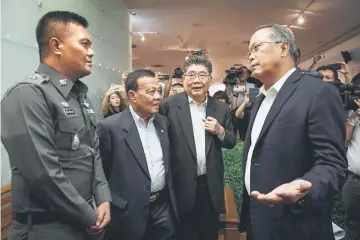  ??  ?? File photo shows Pheu Thai party legal head Chusak Sirinul (right) speaking to a Thai police officer during an attempt to stop a press conference as party officials look on at the party headquarte­rs in Bangkok ahead of the fourth anniversar­y of the May 22, 2014 Thai military coup. — AFP photo