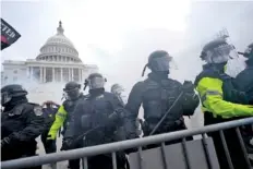  ?? AP PHOTO/JULIO CORTEZ ?? Police stand guard after holding off Trump supporters who tried to break through a police barrier at the Capitol in Washington on Jan. 6.