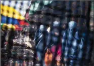  ?? ?? Seen through the eye grid of a burqa, women walk through a market April 11, 2013, in Kabul.