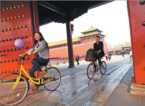  ?? DU JIANPO / FOR CHINA DAILY ?? Tourists riding shared bikes visit the Forbidden City in Beijing on March 18. With the advent of the era of shared bicycles, a variety of colorful bicycles add vibrancy to the Chinese capital.