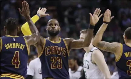  ?? ELISE AMENDOLA — ASSOCIATED PRESS ?? LeBron James trades high-fives with teammates Iman Shumpert, left, and Deron Williams, right, during the first half on May 19